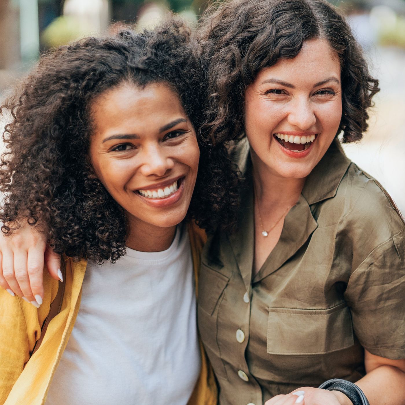 Two women laughing outdoors in Hudson Oaks, capturing joy from forming new friendships later in life.