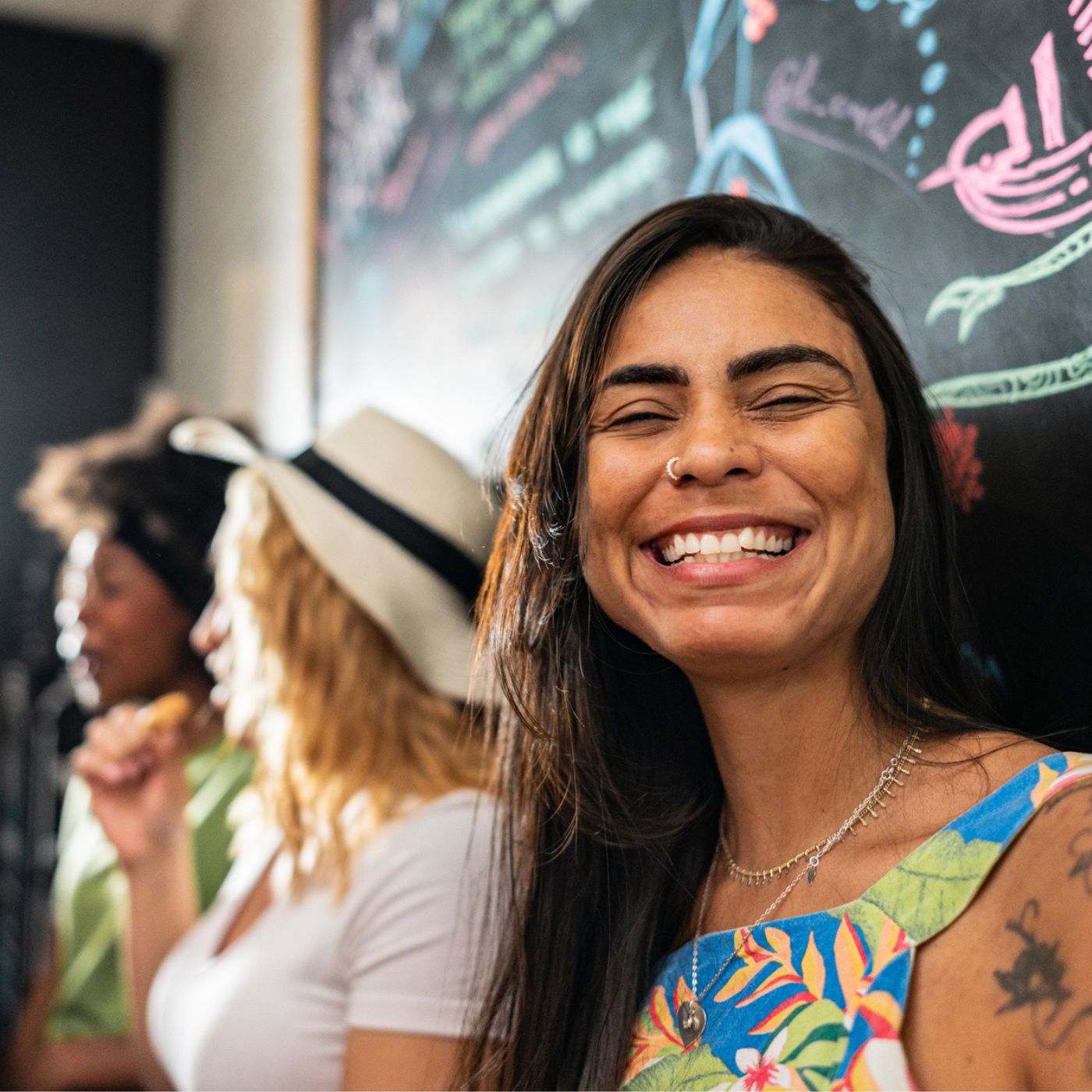 Smiling woman with chatter of friends indoors surrounded by colorful art in Fox Hills