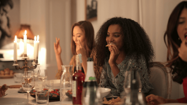 Women enjoying dinner together in a cozy setting, symbolizing friendship and meaningful connections.