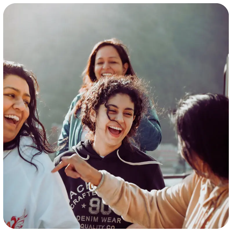 Women laughing together outdoors, showing friendship after 40