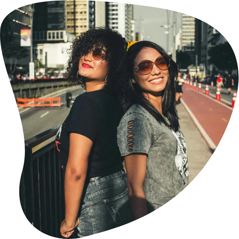 Two women smiling together in a city, representing how to make female friends
