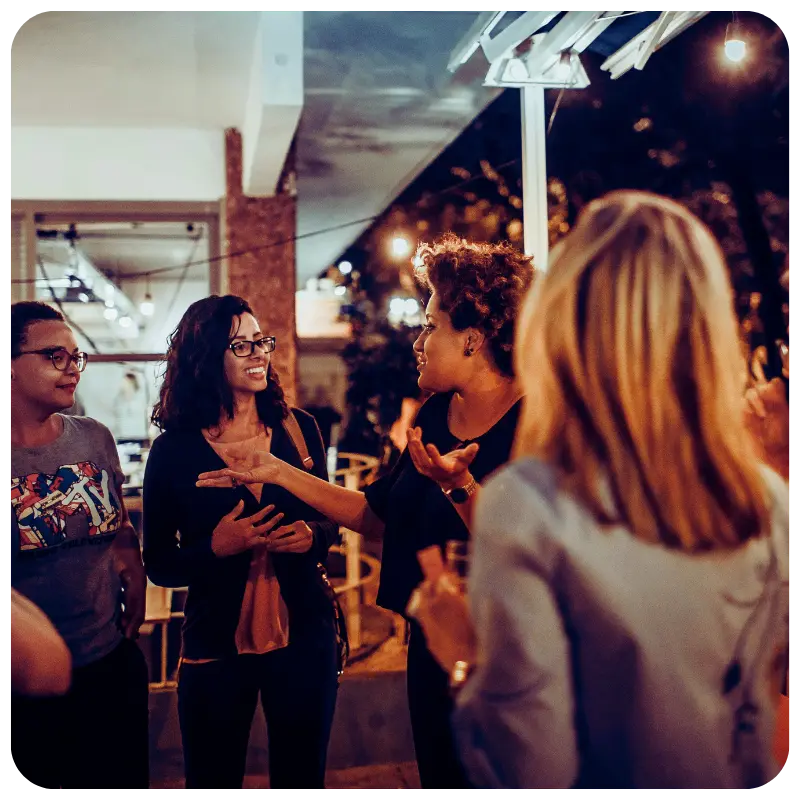 Women meeting and talking at a social gathering, making friends as adults