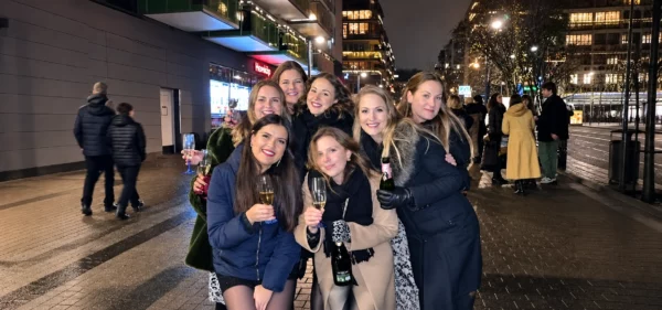 Seven friends celebrating New Year’s Eve together on a city street.