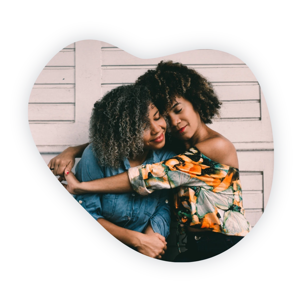 How to make friends as an adult: two women sharing a warm hug outdoors.